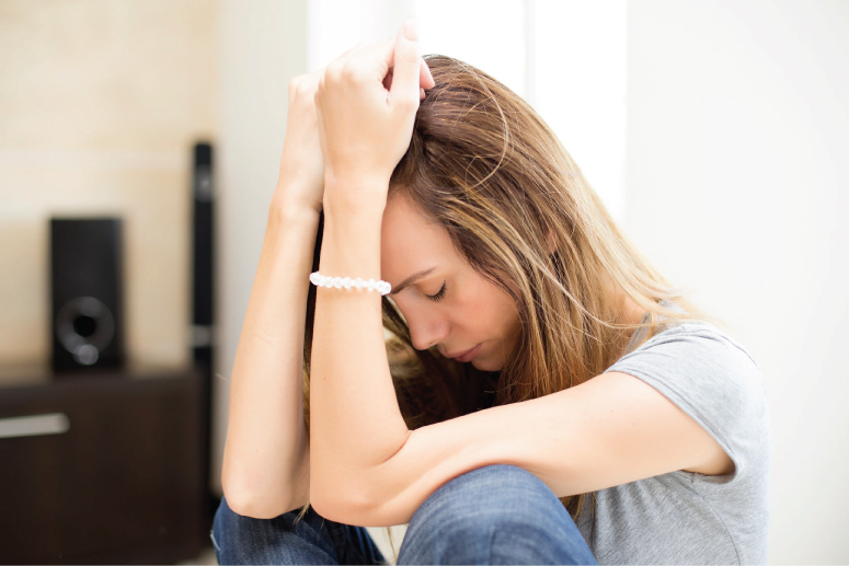 Woman sitting with her head down looking distraught
